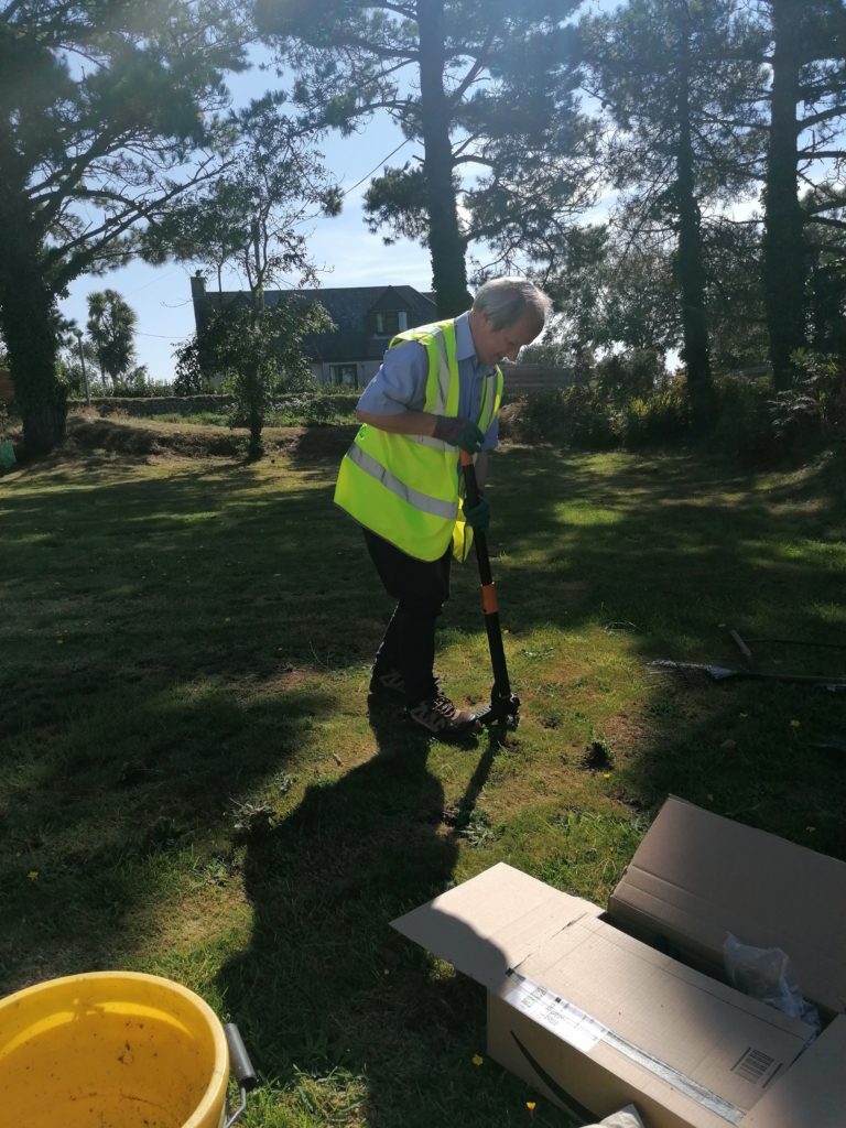 Volunteer digging out dandelions at Polventon